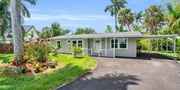 Image 2: Single story home featuring driveway, an attached carport, fence, a front lawn, and a porch