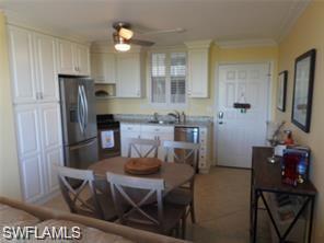 Image 3: Kitchen with ceiling fan, ornamental molding, white cabinetry, stainless steel refrigerator with ice dispenser, and black stove