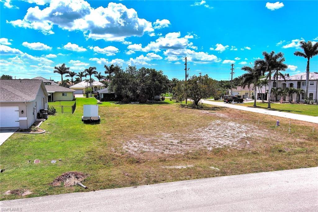 Image 3: View of grassy yard with driveway and a residential view