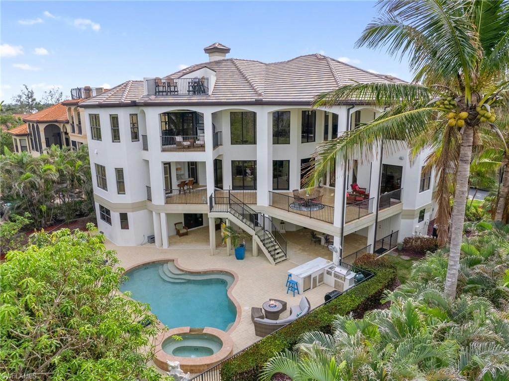 Image 3: Rear view of house featuring a patio area and a pool with hot tub