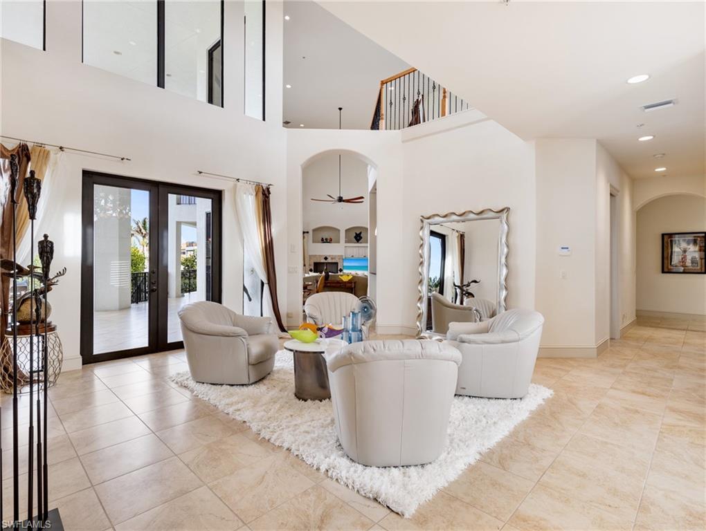 Image 4: Living room with french doors, a towering ceiling, and ceiling fan