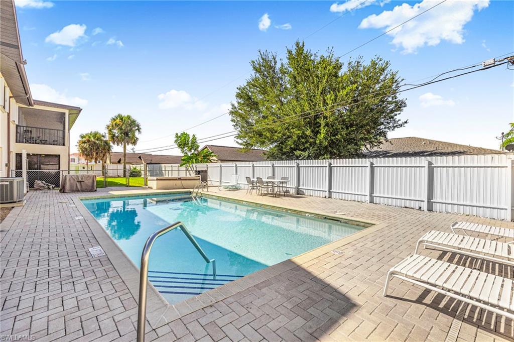 Image 3: Community pool featuring a patio area, a fenced backyard, and a balcony