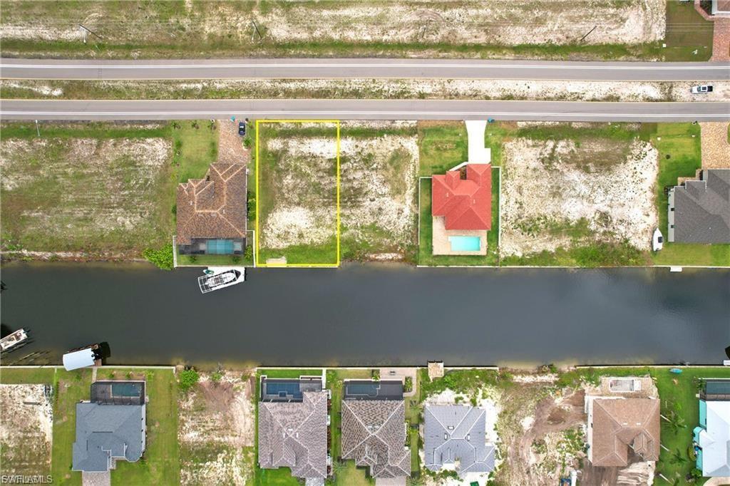 Image 2: Aerial perspective of suburban area with property boundaries highlighted and a large body of water