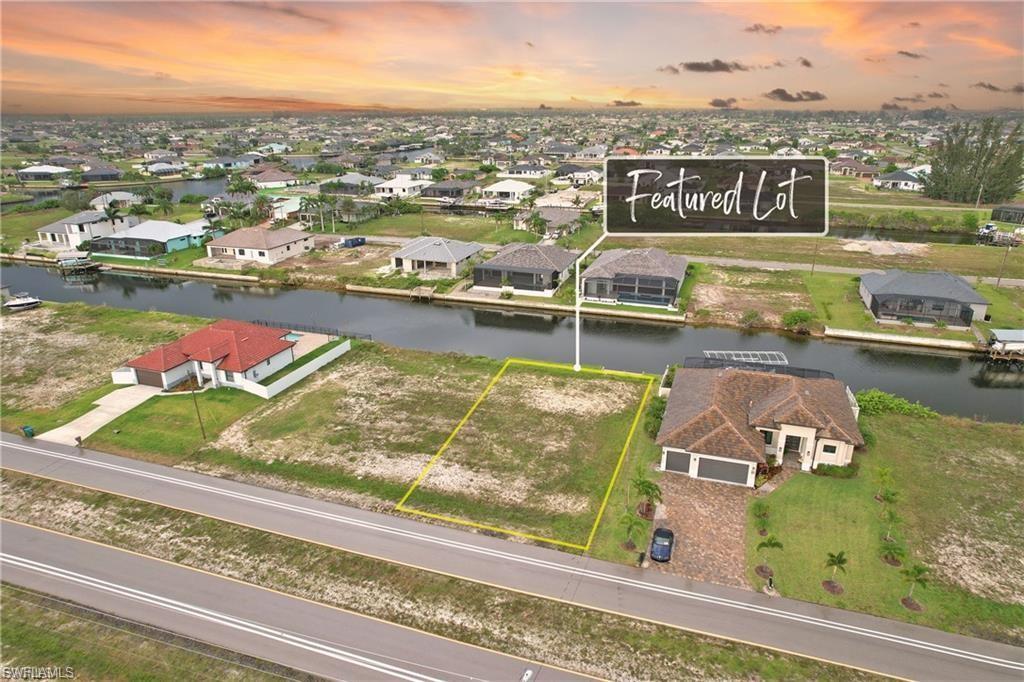Image 3: Aerial view of residential area featuring property parcel outlined and a large body of water