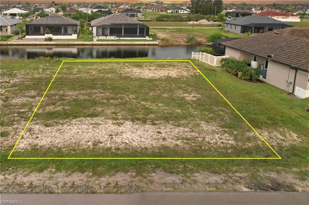 Image 4: Aerial view of residential area with a large body of water and property parcel outlined