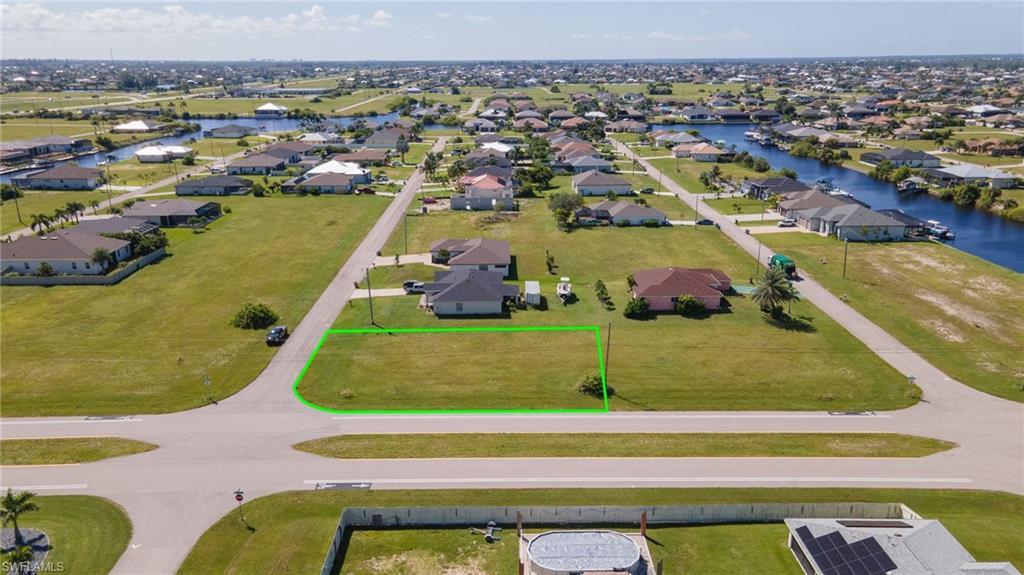Image 4: Aerial view of residential area with a large body of water and property boundaries highlighted