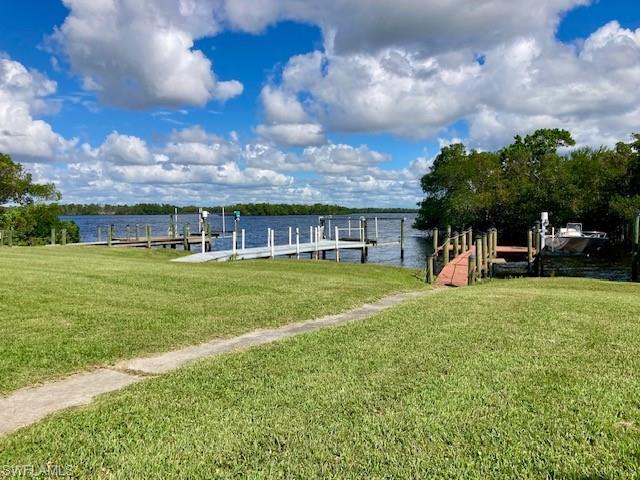 Image 2: Dock with a water view and a lawn