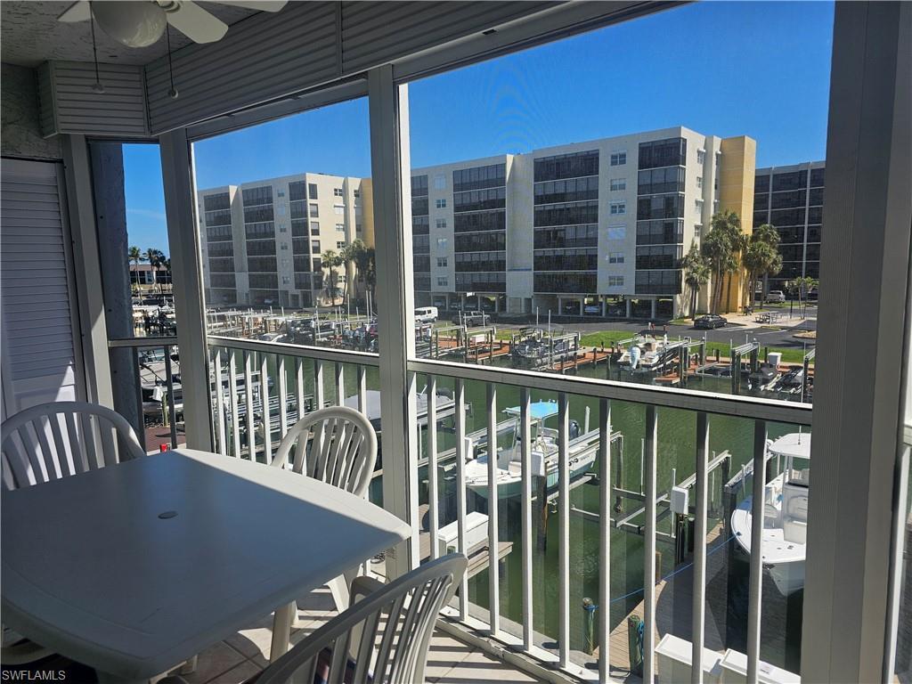 Image 4: Balcony featuring a water view, a ceiling fan, view of marina, and a sunroom