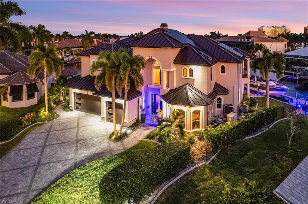Image 1: Mediterranean / spanish home featuring a standing seam roof, a metal roof, concrete driveway, and stucco siding