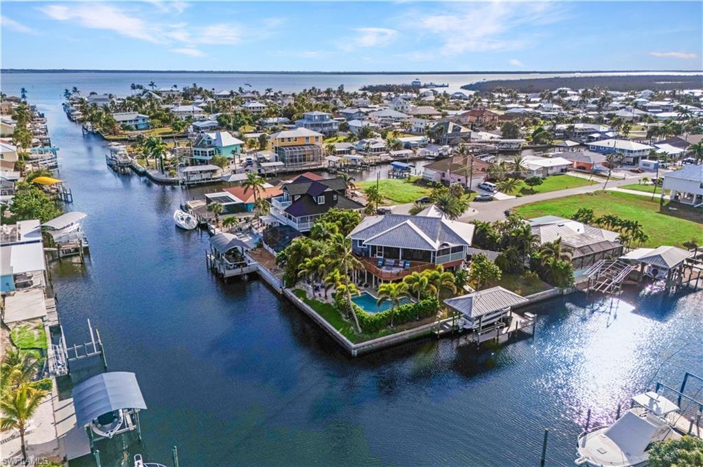 Image 1: Your Private Waterfront Paradise Awaits! Nestled on a peaceful cul-de-sac, this tropical retreat boasts 189 feet of intersecting canal frontage&mdash;where every sunrise and sunset paints the water in gold.  Easy access directly out to the Gulf!