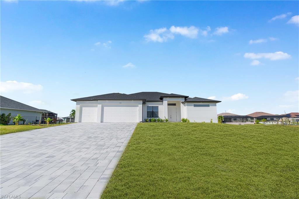Image 1: Prairie-style home with a front yard, a garage, decorative driveway, and stucco siding