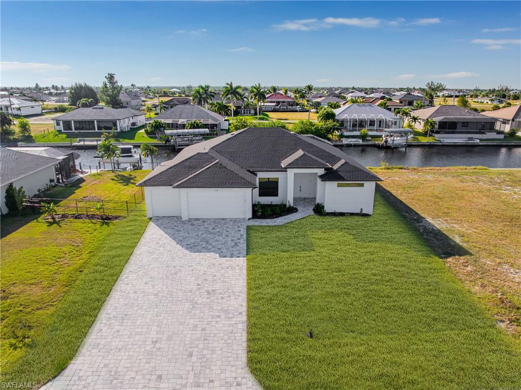Image 2: Aerial view of residential area featuring a nearby body of water