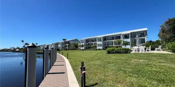 Image 4: Dock featuring a lawn and a water view