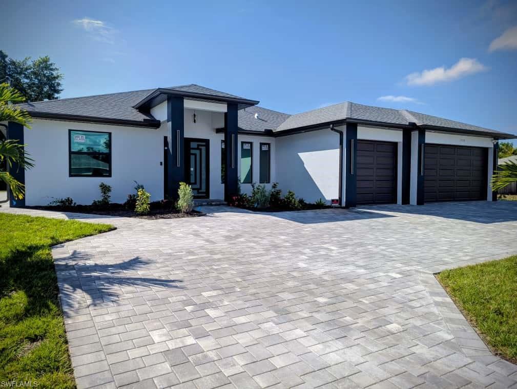 Image 2: Prairie-style home featuring an attached garage, decorative driveway, stucco siding, and roof with shingles