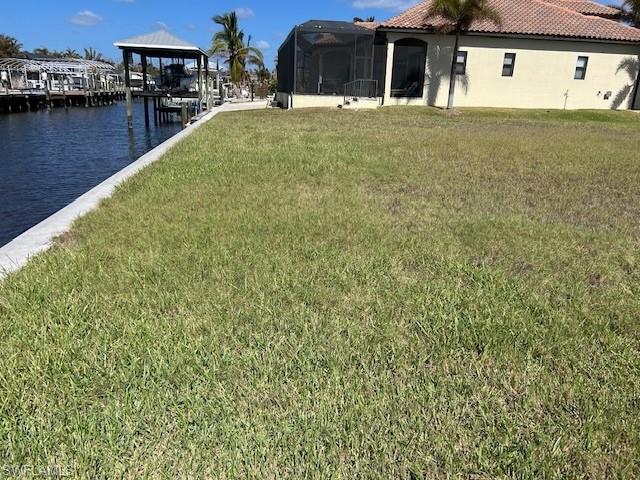 Image 2: View of green lawn featuring a water view and a lanai