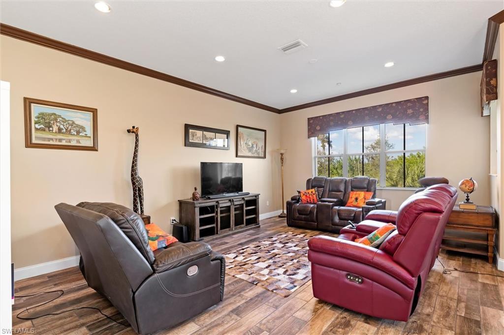 Image 4: Living area with wood finished floors, recessed lighting, and ornamental molding