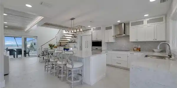 Image 2: Kitchen featuring light stone countertops, plenty of natural light, white cabinetry, a kitchen island, and recessed lighting