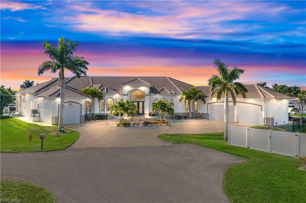Image 1: View of front of house featuring curved driveway, a tile roof, stucco siding, and an attached garage