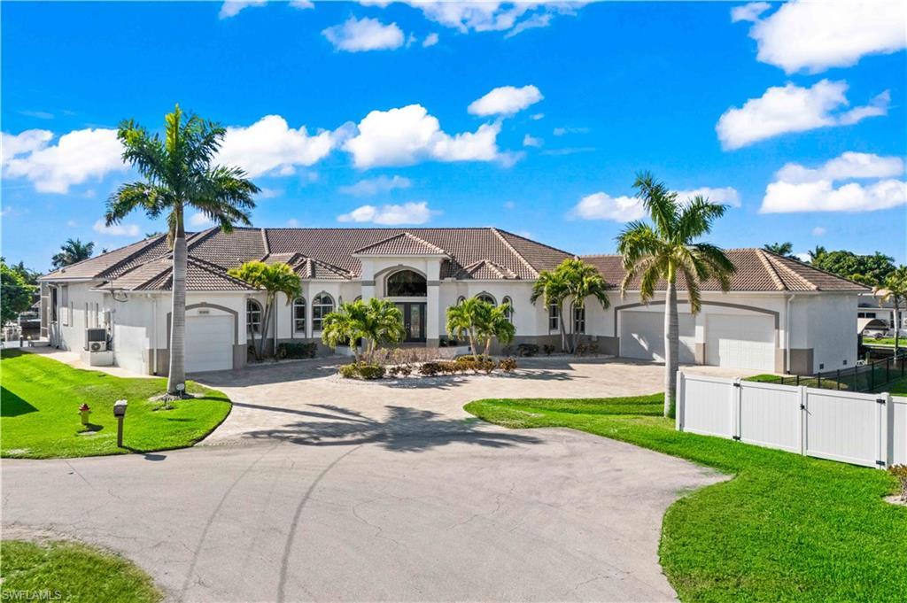 Image 3: Mediterranean / spanish house featuring curved driveway, an attached garage, and stucco siding