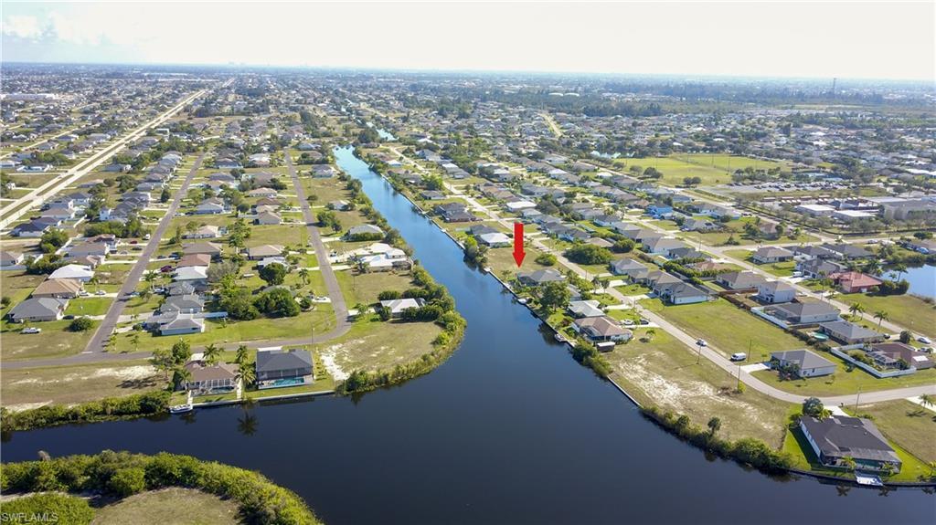 Image 4: Aerial view of property and surrounding area with nearby suburban area and a large body of water