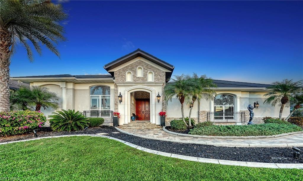 Image 1: View of front of home with stucco siding, stone siding, and a front yard