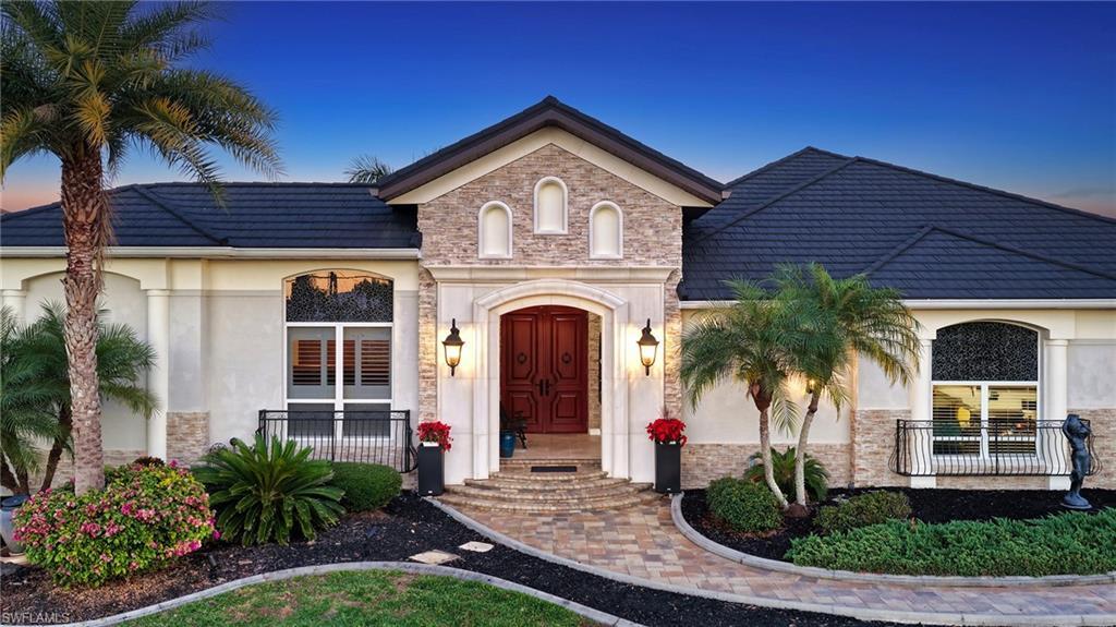 Image 4: View of front facade with stucco siding and stone siding