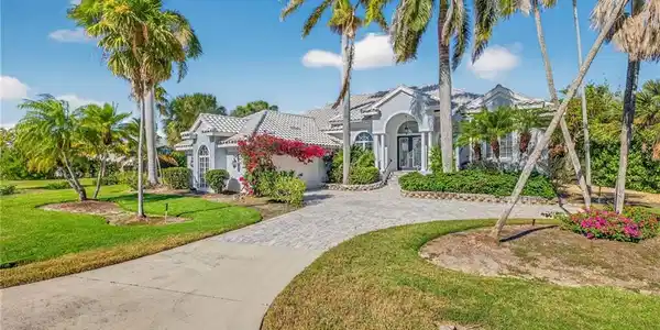 Image 2: View of front of house featuring stucco siding, a front lawn, decorative driveway, an attached garage, and a tile roof