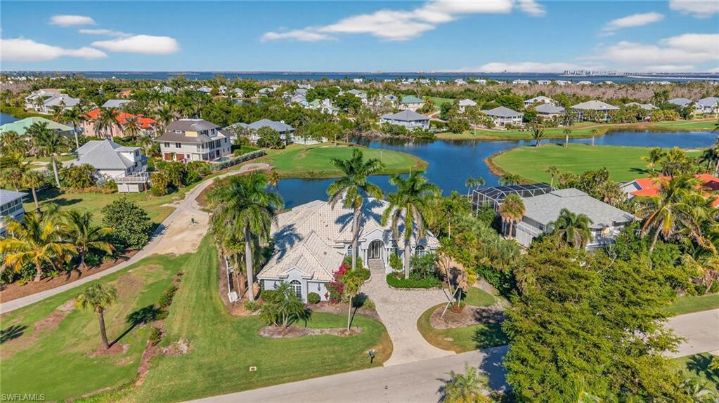 Image 3: Aerial view of property's location with nearby suburban area, a nearby body of water, and a local golf course