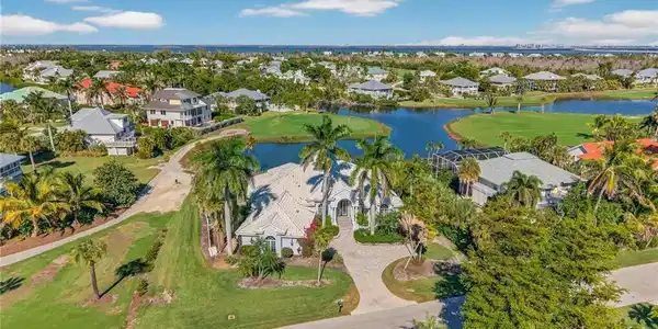 Image 3: Aerial view of property's location with nearby suburban area, a nearby body of water, and a local golf course