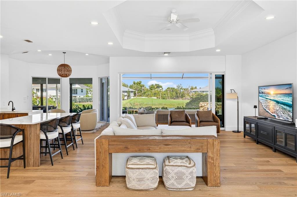 Image 4: Living area with plenty of natural light, ornamental molding, light wood finished floors, ceiling fan, and recessed lighting
