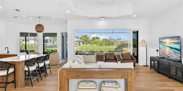 Image 4: Living area with plenty of natural light, ornamental molding, light wood finished floors, ceiling fan, and recessed lighting