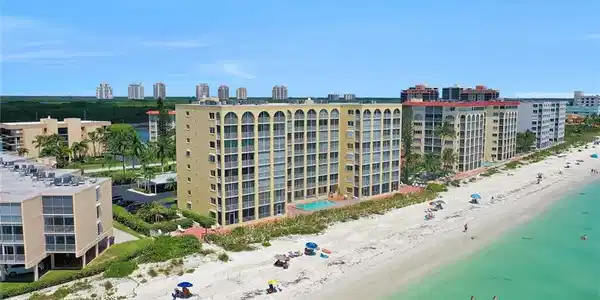 Image 2: Bird's eye view of apartment complex / building and waterfront with a beach