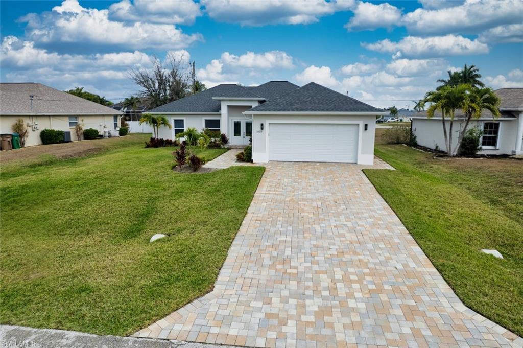 Image 1: Single story home with decorative driveway, a front yard, a garage, and stucco siding