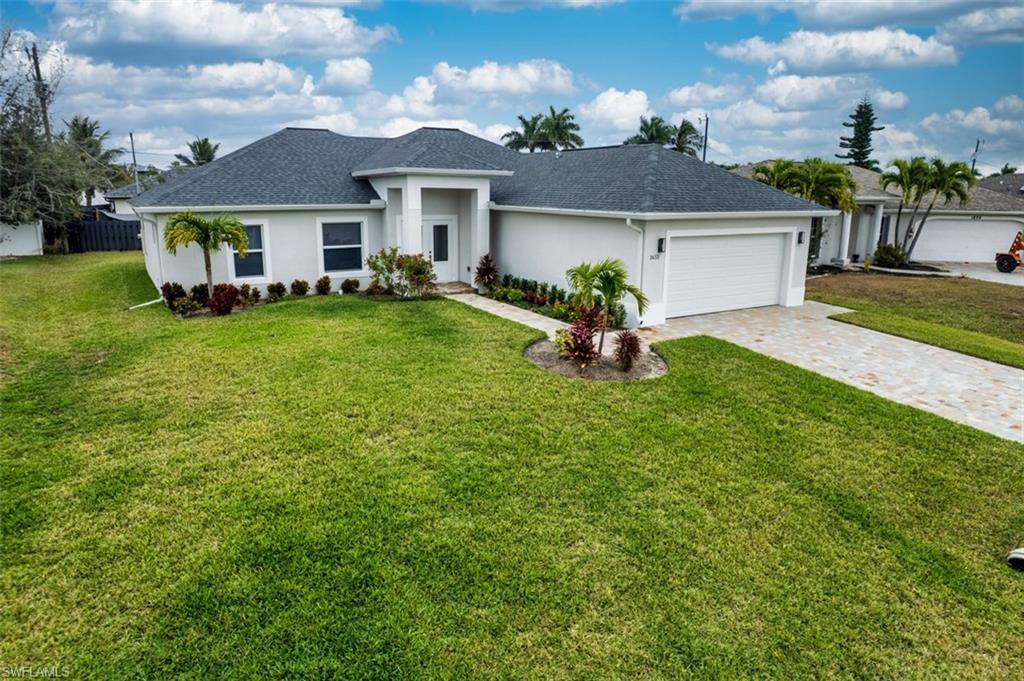 Image 2: Ranch-style home with stucco siding, decorative driveway, an attached garage, and roof with shingles