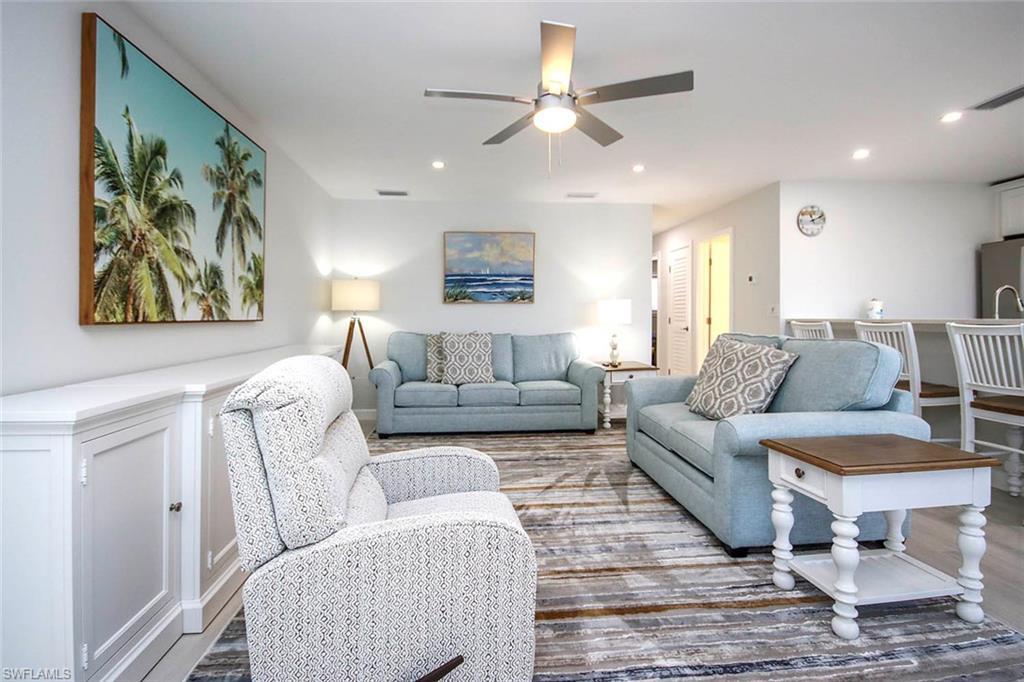 Image 4: Living area with ceiling fan, wood plank tile floors, and recessed lighting