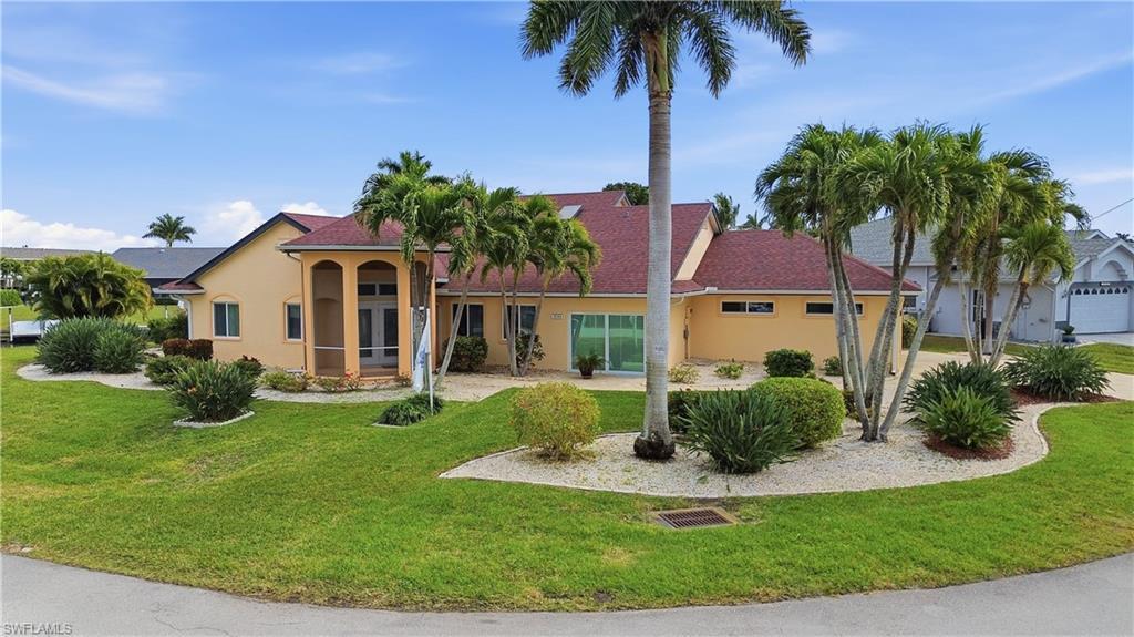 Image 1: Front view of house featuring stucco siding and mature landscaping.