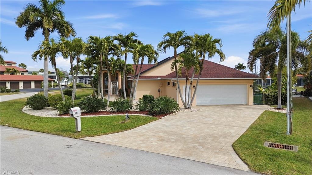 Image 2: Single story home with Paver driveway, a front lawn, garage, and stucco siding