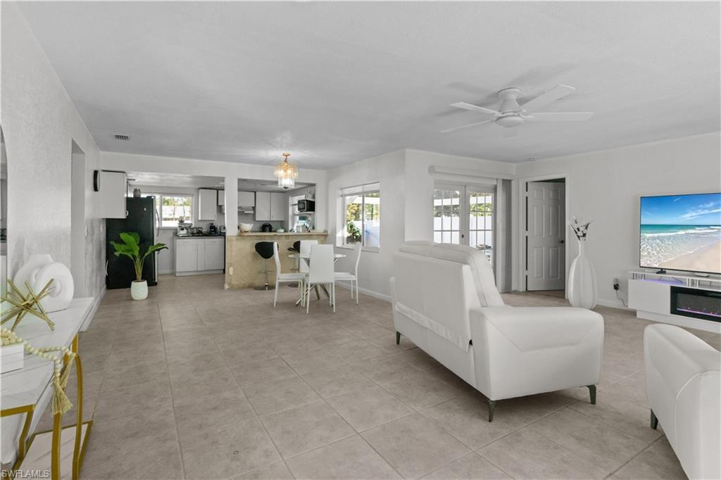 Image 3: Living room featuring a ceiling fan, light tile patterned floors, and french doors