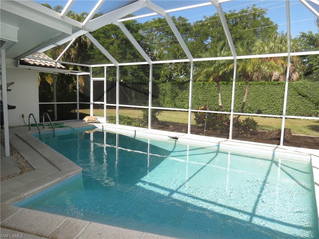 Image 3: View of swimming pool featuring glass enclosure and a patio