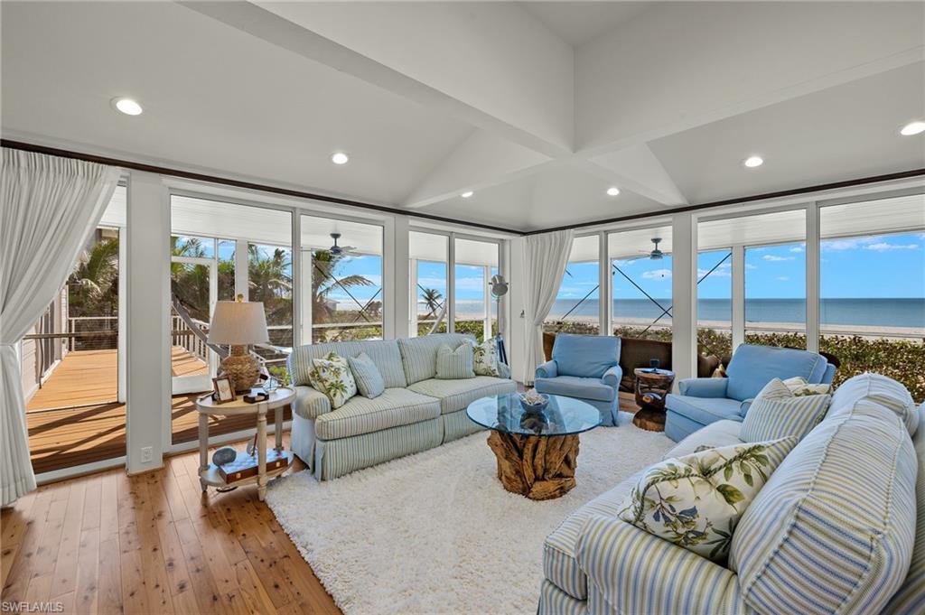 Image 3: Living room with a wealth of natural light, hardwood / wood-style floors, a water view, and beamed ceiling