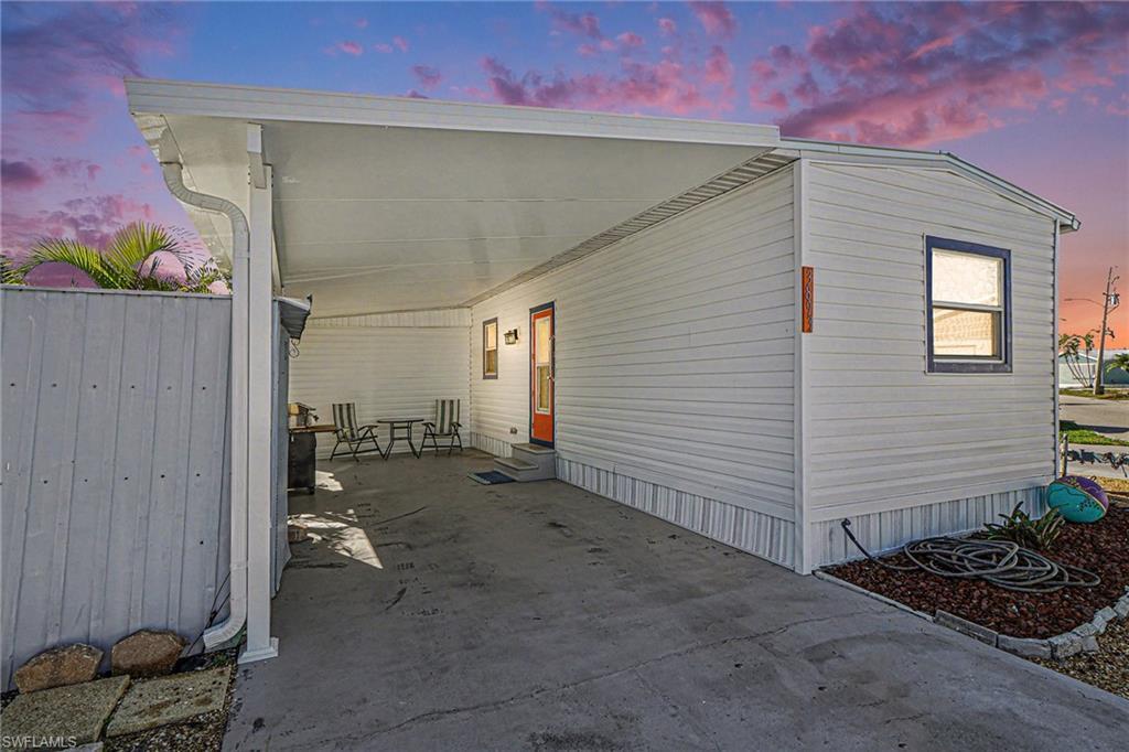 Image 2: View of side of home featuring an attached new carport and entry steps