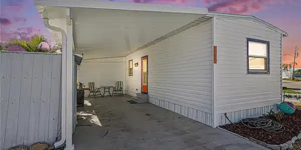 Image 2: View of side of home featuring an attached new carport and entry steps