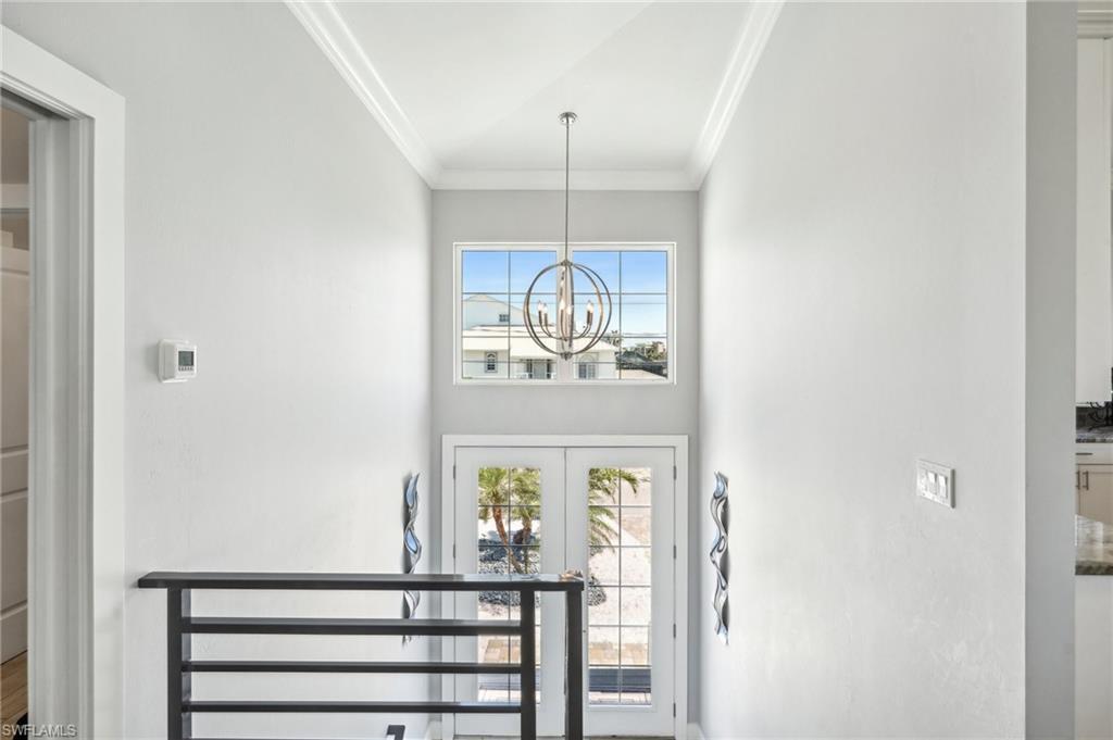 Image 4: Entryway featuring crown molding, an inviting chandelier, and french doors