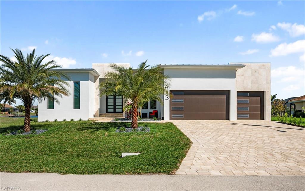 Image 2: Contemporary home with stucco siding, driveway, an attached garage, and a front yard