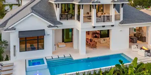 Image 2: Rear view of house featuring an outdoor pool, stucco siding, a tiled roof, a balcony, and a patio area