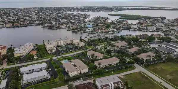 Image 4: Aerial view of property and surrounding area featuring a nearby body of water and nearby suburban area