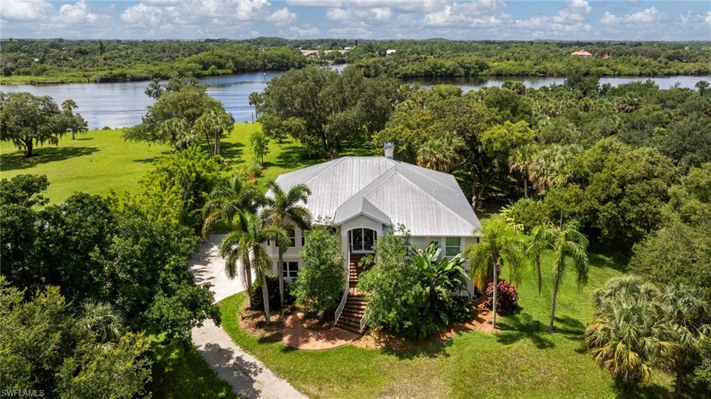 Image 1: View of subject property with a nearby body of water and a heavily wooded area