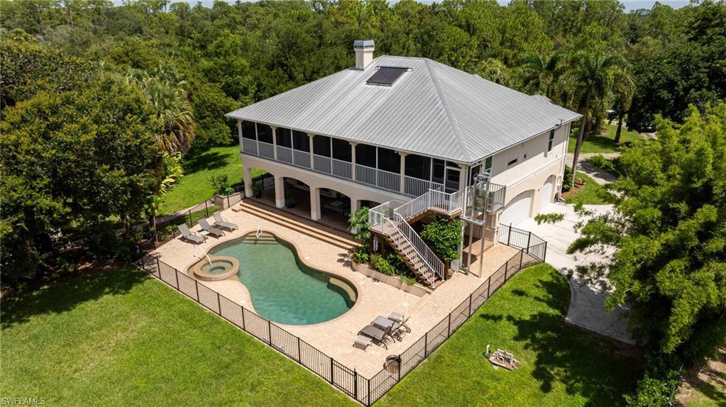 Image 4: Rear view of property with stairway, a fenced backyard, a chimney, a patio area, and a view of trees