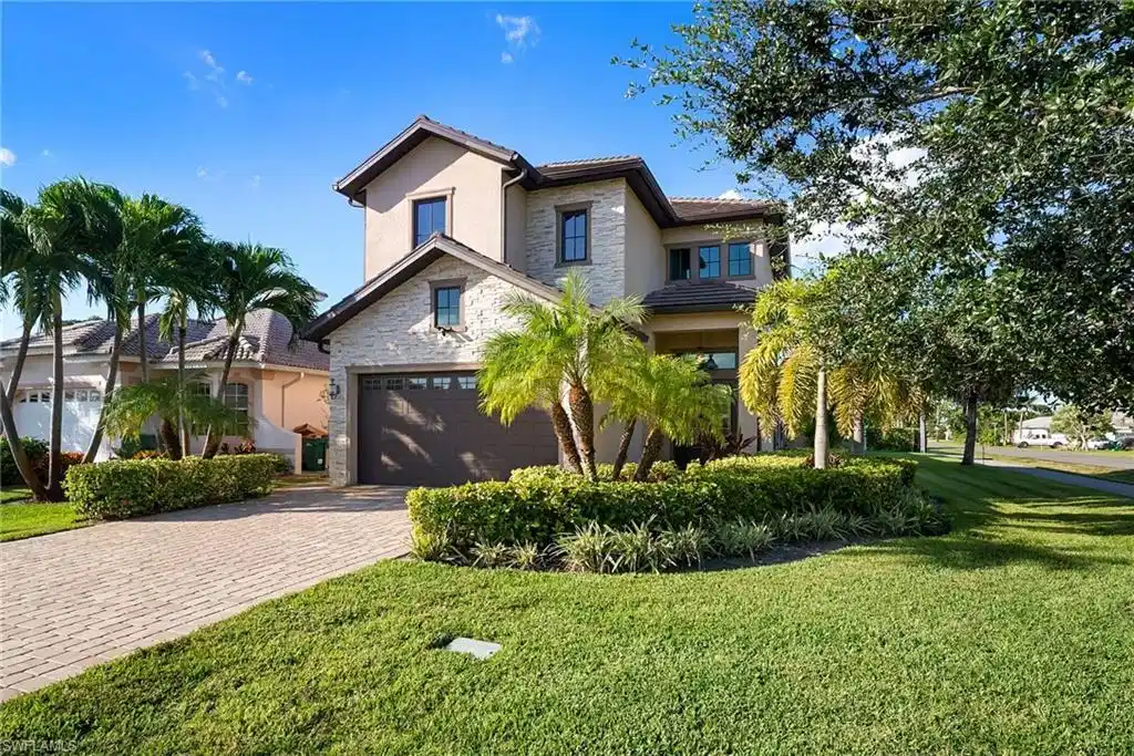 Image 1: View of front of home featuring stone siding, stucco siding, decorative driveway, and a front lawn