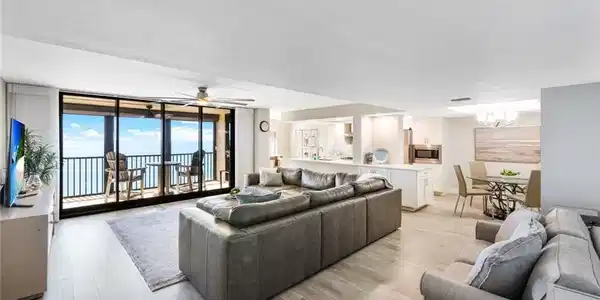 Image 4: Living room featuring expansive windows, light wood-style flooring, ceiling fan, and a chandelier